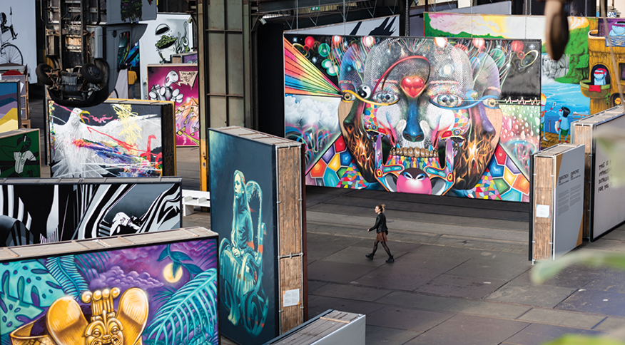 Vrouw loopt door STRAAT, het Amsterdamse museum voor street art en graffiti in een voormalige NSDM-scheepsloods.