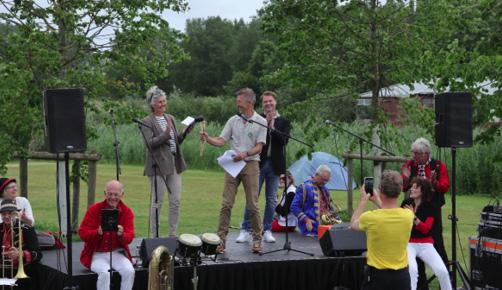 Het bestuur bij het feest op 2 juni. Links op het podium, staand is Willemieke de Waal. In het midden Toon Weijenborg en rechts Pascal de Gouy.